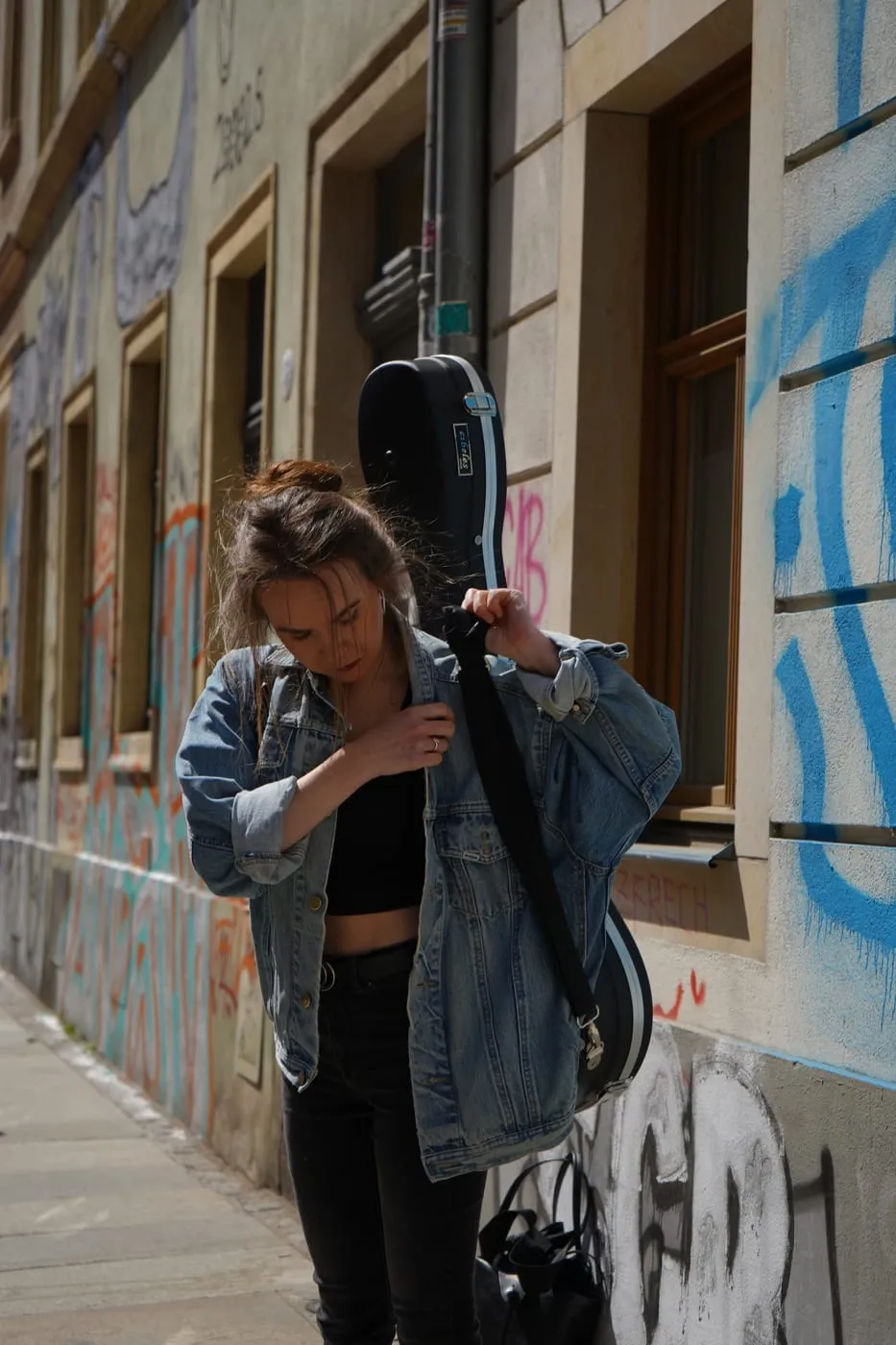 Margaréta Lakner with her guitar case on a Dresden street